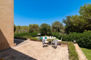 a patio with a table and chairs in a yard at Villa Comellar by Sealand Villas in Artá