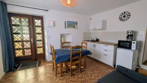 a kitchen with a table and chairs and a microwave at Gîte des hauts gris in Vions