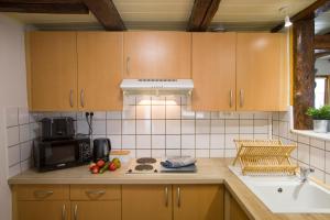 a kitchen with wooden cabinets and a stove top oven at L'authentique bleuet d'Alsace in Wettolsheim +14 photos