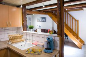 a kitchen with a sink and a staircase at L'authentique bleuet d'Alsace in Wettolsheim