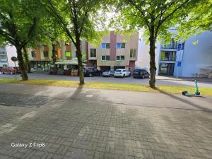 a sidewalk with trees and a scooter on a street at Willa Ranna Resort in Pärnu