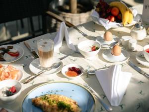 a table with a plate of food and eggs on it at Hotel Kaiserhof Kitzbühel, 4 Sterne Superior in Kitzbühel