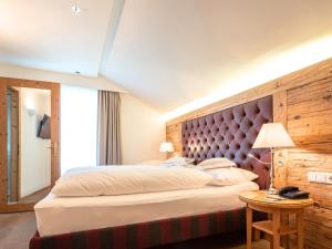 a bedroom with a large bed with a large headboard at Hotel Kaiserhof Kitzbühel, 4 Sterne Superior in Kitzbühel +68 photos