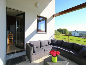 a patio with a couch and a table with flowers at Escape with Bubble Bath in Martilly