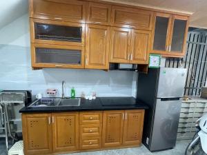 a kitchen with wooden cabinets and a stainless steel refrigerator at The Rose House-Lakeview Long Bien in Hanoi