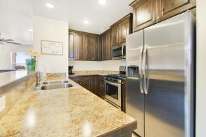 eine Küche mit Holzschränken und einem Edelstahlkühlschrank in der Unterkunft Rim Vista 17A2 in Moab