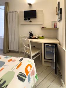 a small room with a desk and a table with a chair at BelSorrisoVarese - Rooms & Apartments - Private Parking - Reservation Required in Varese