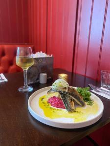 a plate of food on a table with a glass of wine at The Raven Pub with Rooms in Claines