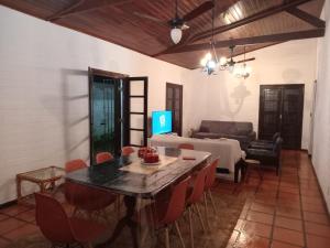 a living room with a table and chairs and a couch at CASA ENSEADA - Ótima localização in Guarujá