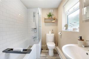 a bathroom with a tub and a toilet and a sink at Horatio House - North East Escapes in Monkwearmouth +25 photos