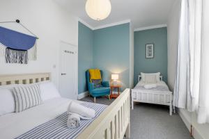 a bedroom with two beds and a blue wall at Horatio House - North East Escapes in Monkwearmouth