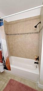 La salle de bains est pourvue d'une baignoire blanche et d'un tapis rose. dans l'établissement Bungalow DT by Lake Eola KIA center Sleeps 12, à Orlando 36 autres photos