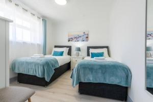 two beds sitting next to each other in a bedroom at Home from Home near the beach in Port Talbot