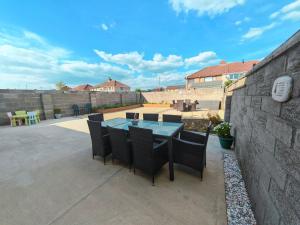 a patio with a table and chairs and a wall at Home from Home near the beach in Port Talbot