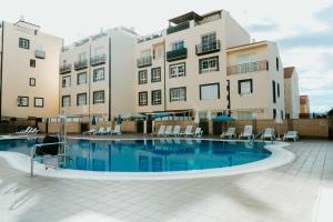 a swimming pool in front of a building at Spacious 2 BR Golden Apartment by Aqua Vista Tenerife in Callao Salvaje