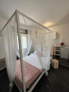 Un dormitorio con una cama con dosel y cortinas blancas. en La loge du Paul B, en Nantes