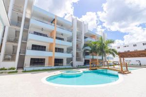 バヤイベにあるCaribbean Pearl 2BR Bayahíbe Stayの大きな建物で、目の前にスイミングプールがあります。