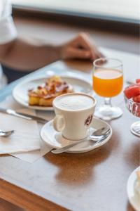 ein Tisch mit einer Tasse Kaffee und einem Teller Essen in der Unterkunft Lake Hotel Ifigenia in Nago-Torbole