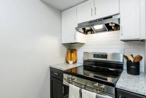 a kitchen with a stove and white cabinets at Silverstone Luxury Huntsville Extended Stay in Huntsville +6 photos