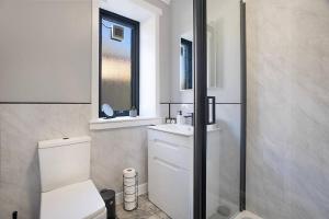 Un baño con inodoro, lavabo y espejo. en Hilton Road Apartment - Grampian Lettings, en Aberdeen