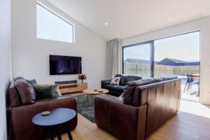 a living room with a couch and a table at Prowess Lodge luxury accommodation with private pool and spa in Wanaka