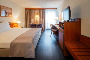 ein Hotelzimmer mit Bett und Flachbildfernseher in der Unterkunft Hotel Münchwilen in Wil