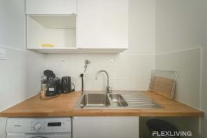 パリにあるCozy Room in Alésia Paris 14thのシンクとカウンタートップのあるキッチン