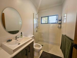 a bathroom with a sink and a toilet and a mirror at Garden Street Haven in Cooktown +20 photos