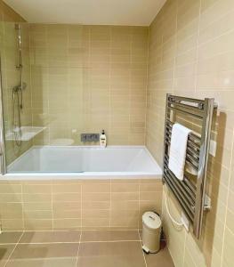 bagno con vasca, doccia e servizi igienici di Modern Central Apartment with Parking a Cambridge