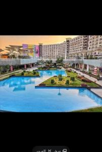 a large swimming pool in front of a large building at بورتو كايرو التجمع الخامس in Cairo
