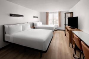 a hotel room with two beds and a television at StudioRes by Marriott Fort Myers Airport in Miromar Lakes