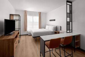 a hotel room with a bed and a table and chairs at StudioRes Fort Myers in Fort Myers