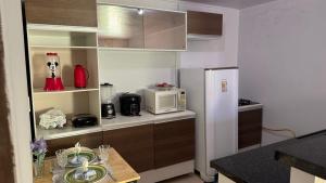 a kitchen with a refrigerator and a microwave at Minha mini casa aconchegante de 2 quartos e 2 camas de casal in Juazeiro do Norte +24 photos