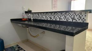 a bathroom with a black counter and a sink at Minha mini casa aconchegante de 2 quartos e 2 camas de casal in Juazeiro do Norte