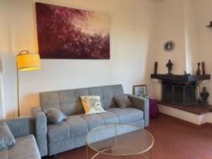 a living room with a couch and a glass table at Villa Rosanna - views and woods near Florence in San Donato in Collina