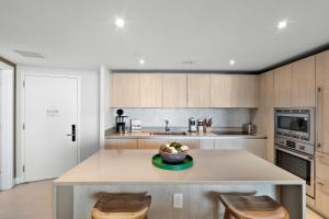 una cocina con mesa con sillas y un bol de fruta. en Picturesque Beachfront Condo - LOVELY 2BD and 2BA APT WITH DIRECT OCEAN VIEW, en Hollywood