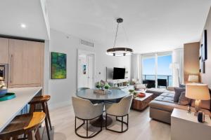 a kitchen and living room with a table and chairs at PRICE REDUCED DUE TO FLOOR COSMETIC DAMAGE - Picturesque Beachfront Condo - LOVELY 2BD and 2BA APT WITH DIRECT OCEAN VIEW in Hollywood