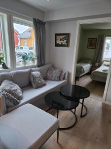 ein Wohnzimmer mit Sofa und Tisch in der Unterkunft Flott moderne leilighet meget sentralt i vakre Sørbyen i Brønnøysund for inntil 5 pers in Brønnøysund