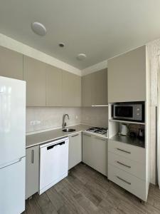 an empty kitchen with white cabinets and appliances at Shekvetili Small Wonder in Shekhvetili +11 photos