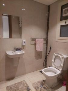 a bathroom with a toilet and a sink at بورتو كايرو التجمع الخامس in Cairo +10 photos