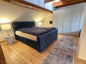 a bedroom with a large blue bed in a room at RitterLiving Ferienapartment am Markt in Tangermünde