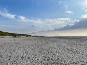 a sandy beach with footprints in the sand at 8 person holiday home in Henne in Henne Strand
