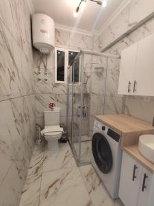 a bathroom with a toilet and a washing machine at Kariani Sea View Chic Apartment in Karianí