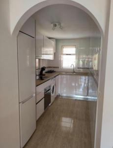 a white kitchen with an archway in the middle at Casa Sol y Sal Fuerteventura in La Oliva