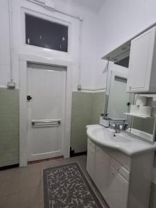 a bathroom with a sink and a door with a mirror at Venetian Haven BnB in Venice