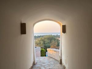 タナウネッラにあるAlba Vista Mare - Apartment mit Meerblick und Pool Budoni, Sardinienの海の見える建物のアーチ道