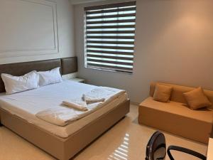 a bedroom with a bed and a window and a couch at Swarn Hotel in Kolkata