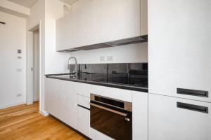 a kitchen with white cabinets and a stove top oven at GiaxTower Gym Spa & Pool Skyline View 20' piano in Milan