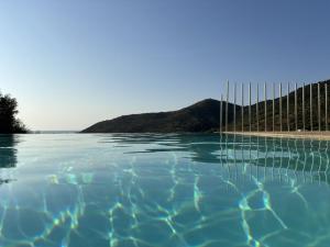 タナウネッラにあるAlba Vista Mare - Apartment mit Meerblick und Pool Budoni, Sardinienの水中のフェンス付きスイミングプール