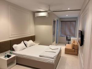 a small bedroom with a bed and a chair at Swarn Hotel in Kolkata